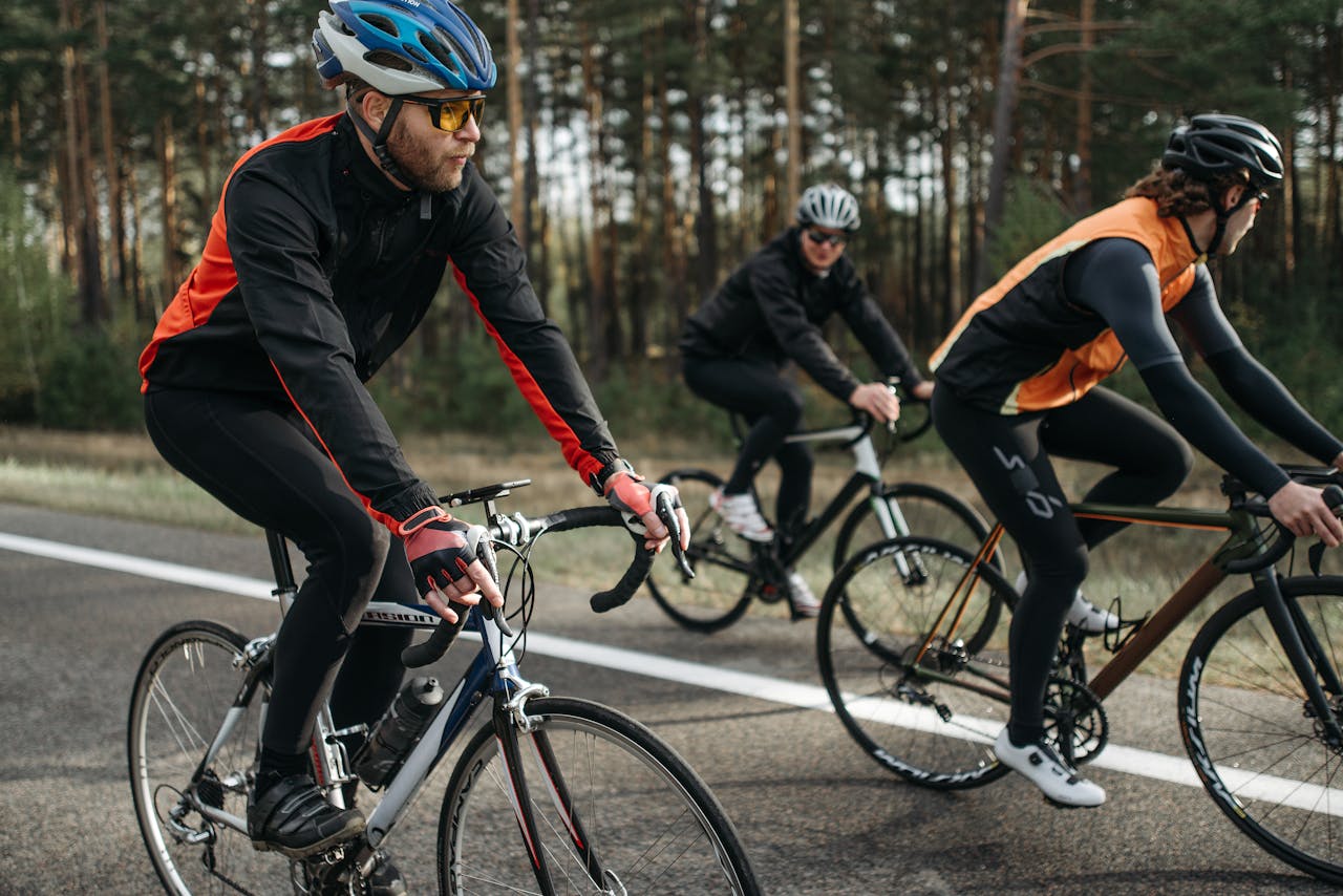 Group of cyclists on a scenic outdoor road, showcasing speed and athleticism.